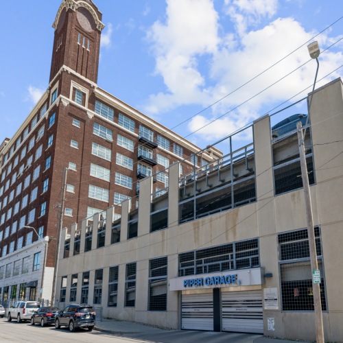 Piper Lofts parking garage in Kansas City with adjacent historic building and clear blue sky