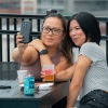 two girls sitting on the rooftop taking a selfie