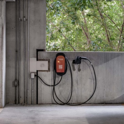 Electric vehicle charging station located in Piper Lofts parking garage with car parked nearby